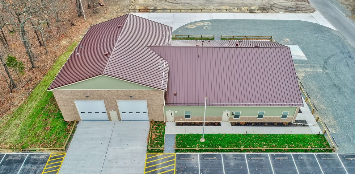Man Using Measuring Tape in Factory Setting Man Using Measuring Tape in Factory Setting